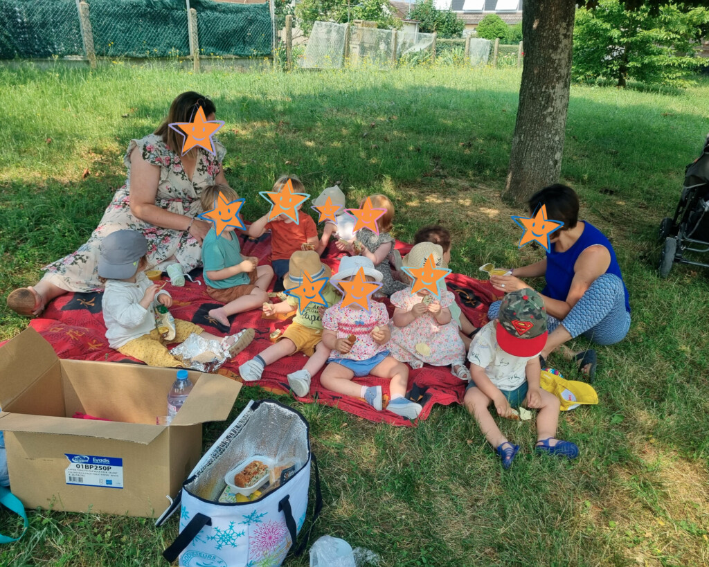 Enfants déjeunant à l'extérieur avec deux professionnelles