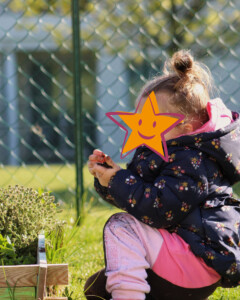 petite fille qui sent les aromates du potager